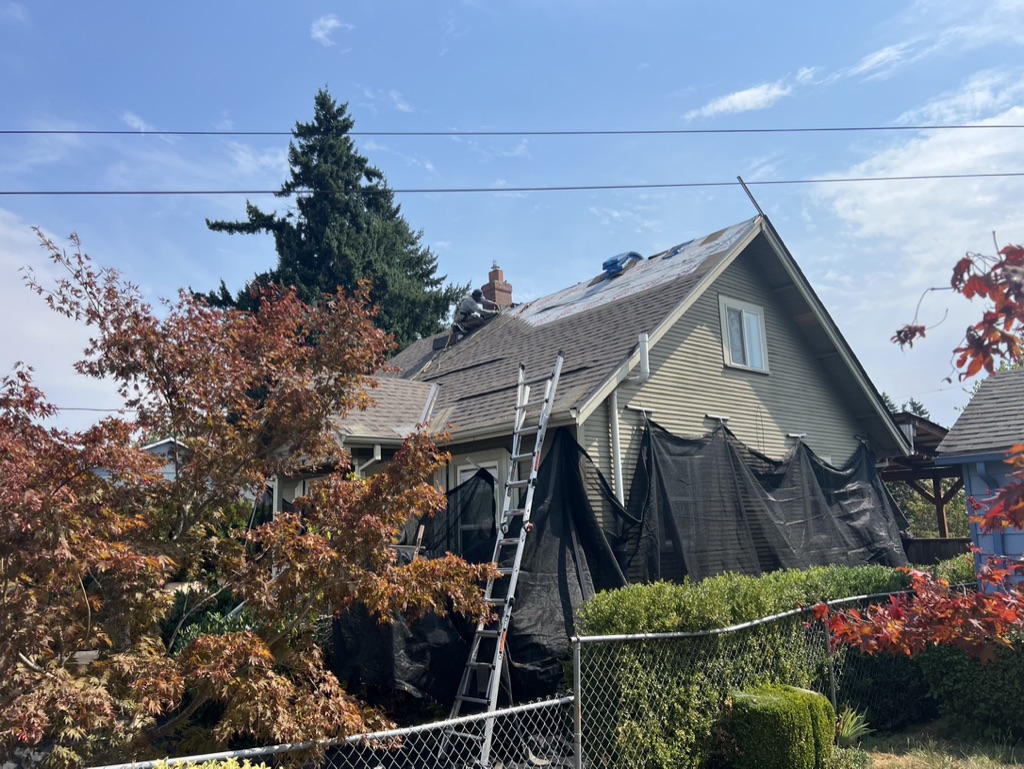 Evolution RoofWorks crew replacing a roof on a Portland home — shingles stripped and underlayment exposed